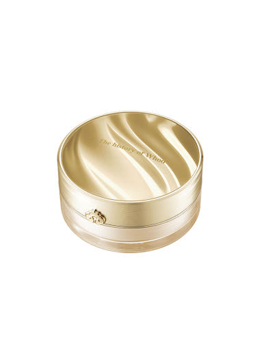 Gold cosmetic container on a light gray background